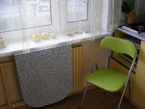 Мойка у окна в маленькой кухне. Столешница у кухонного окна