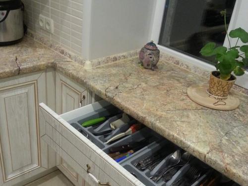 Мойка у окна в маленькой кухне. Столешница у кухонного окна