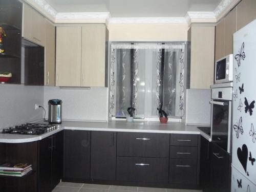 Мойка у окна в маленькой кухне. Столешница у кухонного окна