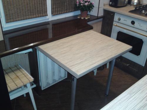 Мойка у окна в маленькой кухне. Столешница у кухонного окна