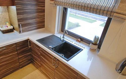 Раковина под окном на кухне.