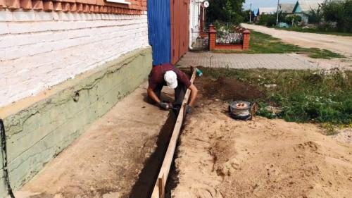Отмостка вокруг старого дома. Процесс ремонта разрушенной отмостки