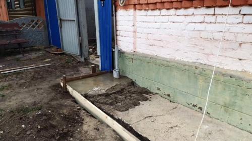 Отмостка вокруг старого дома. Процесс ремонта разрушенной отмостки