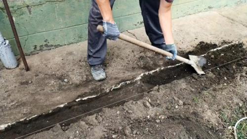 Отмостка вокруг старого дома. Процесс ремонта разрушенной отмостки